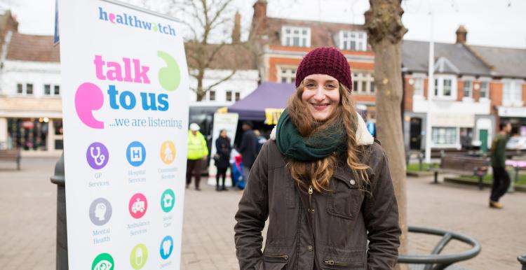 Healthwatch Staff member infront of some branded promotional material at a Healthwatch event